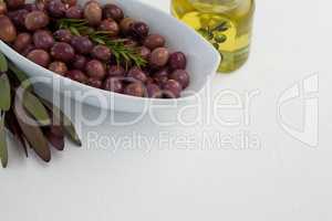 Close up of olives and rosemary with oil in jar