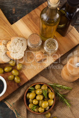 High angle view of olives and oils bottles with bread