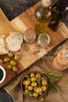 High angle view of olives and oils bottles with bread