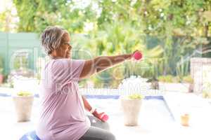 Side view of woman exercising with dumbbells