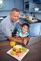 Portrait of grandfather and son at table