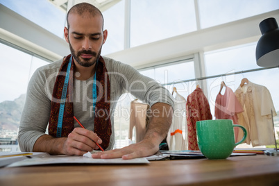 Male designer drawing sketch while sitting at table