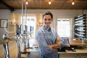 Smiling man with arms crossed at counter in restaurant