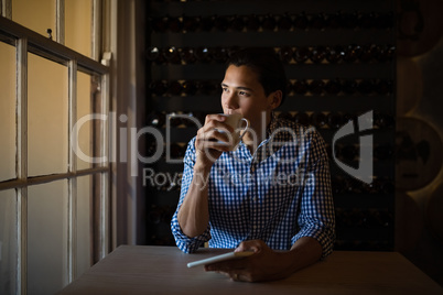 Man having coffee and holding digital tablet in restaurant