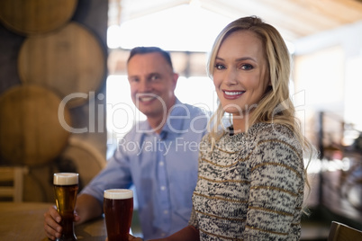 Happy couple holding glasses of beer in bar