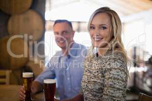 Happy couple holding glasses of beer in bar