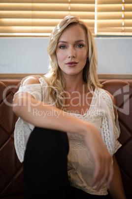 Beautiful woman sitting on sofa in restaurant