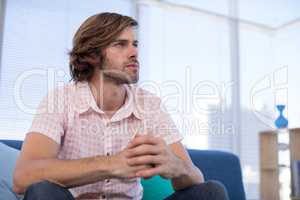 Depressed male executive sitting on sofa