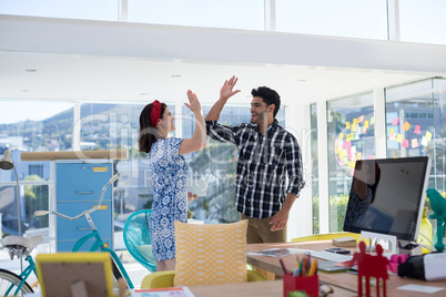 Couple giving high five to each other in the office