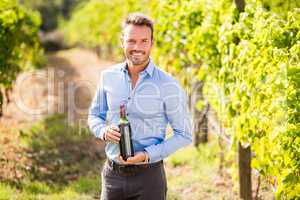 Portrait of smiling man holding wine bottle