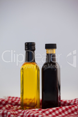 Close up of green and black olive oil in bottle on napkin
