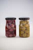 Close up of brown and green olives in jar