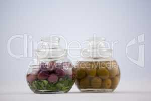 Close up of red and green olives in glass jar