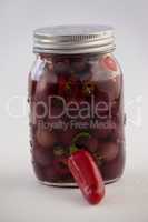 Close up of red olives with jalapeno in container