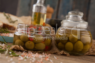 Close up of green olive in glass jars