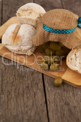 Olives in jar wrapped with jute by bread