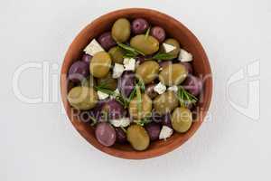Olives with cheese and rosemary served in bowl