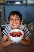 Close up portrait of boy showing cereal breakfast