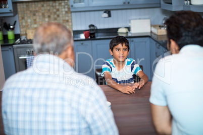 High angle view of father and grandfather talking to boy