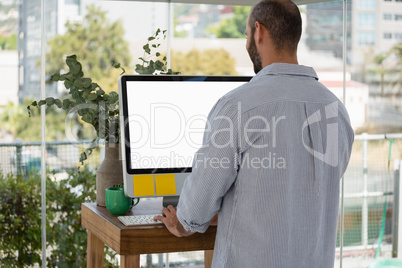Rear view of designer using computer in office