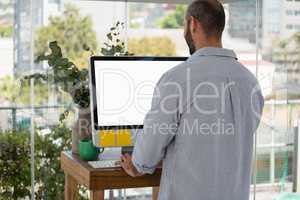 Rear view of designer using computer in office