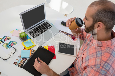 Designer writing on graphics tablet while sitting at desk