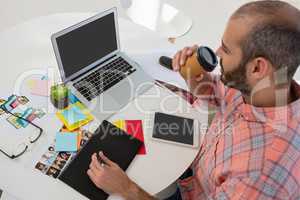 Designer writing on graphics tablet while sitting at desk