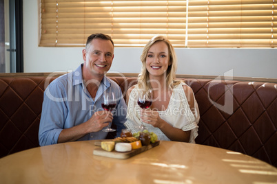 Happy couple holding wine glass while having meal