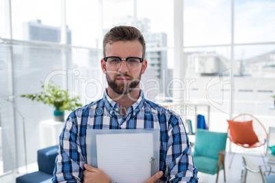 Male executive holding a document in the office