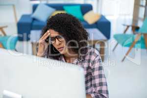 Female executive suffering from headache at desk