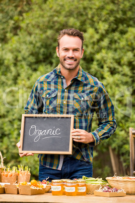 Portrait of man with blackboard selling vegetables