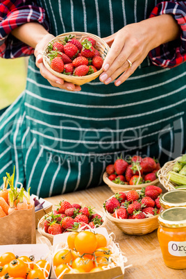 Midsection of woman selling strawberries