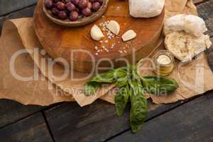 High angle view of black olives with herb and garlic by bread