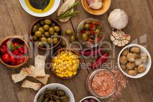 Olives with vegetable and spice by oil in bowl on table