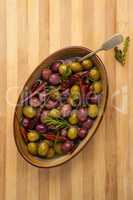 Overhead view of olives with red chili pepper and herb