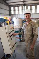 Portrait of happy technician operating a machine