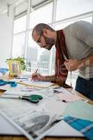 Male designer drawing sketch at table in studio