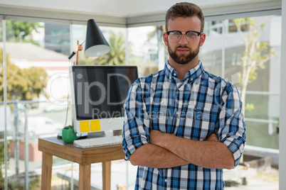 Portrait of businessman with arms crossed in office