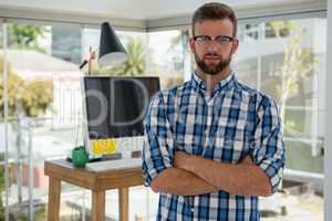 Portrait of businessman with arms crossed in office