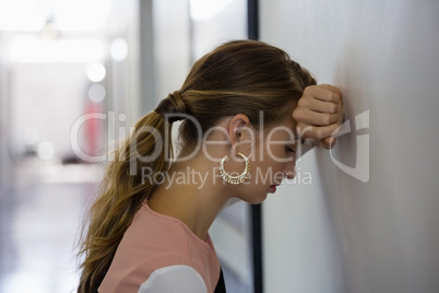 Sad businesswoman leaning on wall