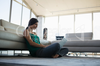 Young woman working by using laptop at office