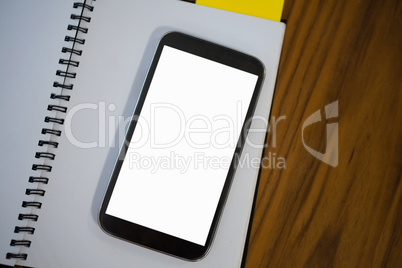 High angle view of note pad with phone on table in office