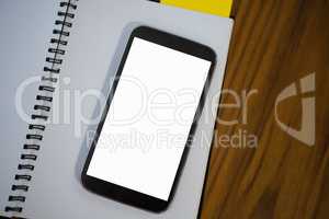 High angle view of note pad with phone on table in office