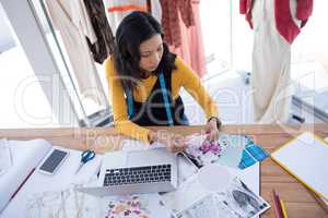 Female designer working on pieces of clothes