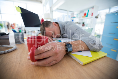 Tired male executive sleeping on desk