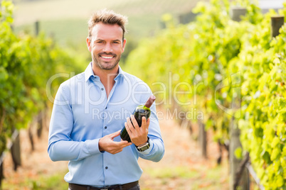 Portrait of man holding wine bottle