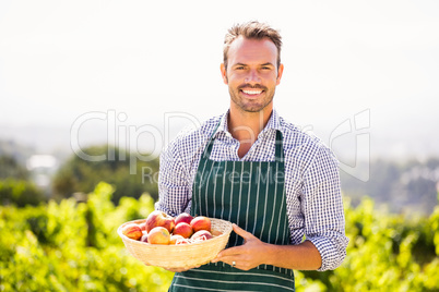 Portrait of young man holding apple basket