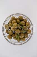 Overhead view of green olives in glass bowl