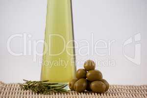 Green olives and rosemary by oil in bottle