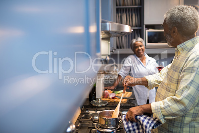 Couple talking while preparing food at home